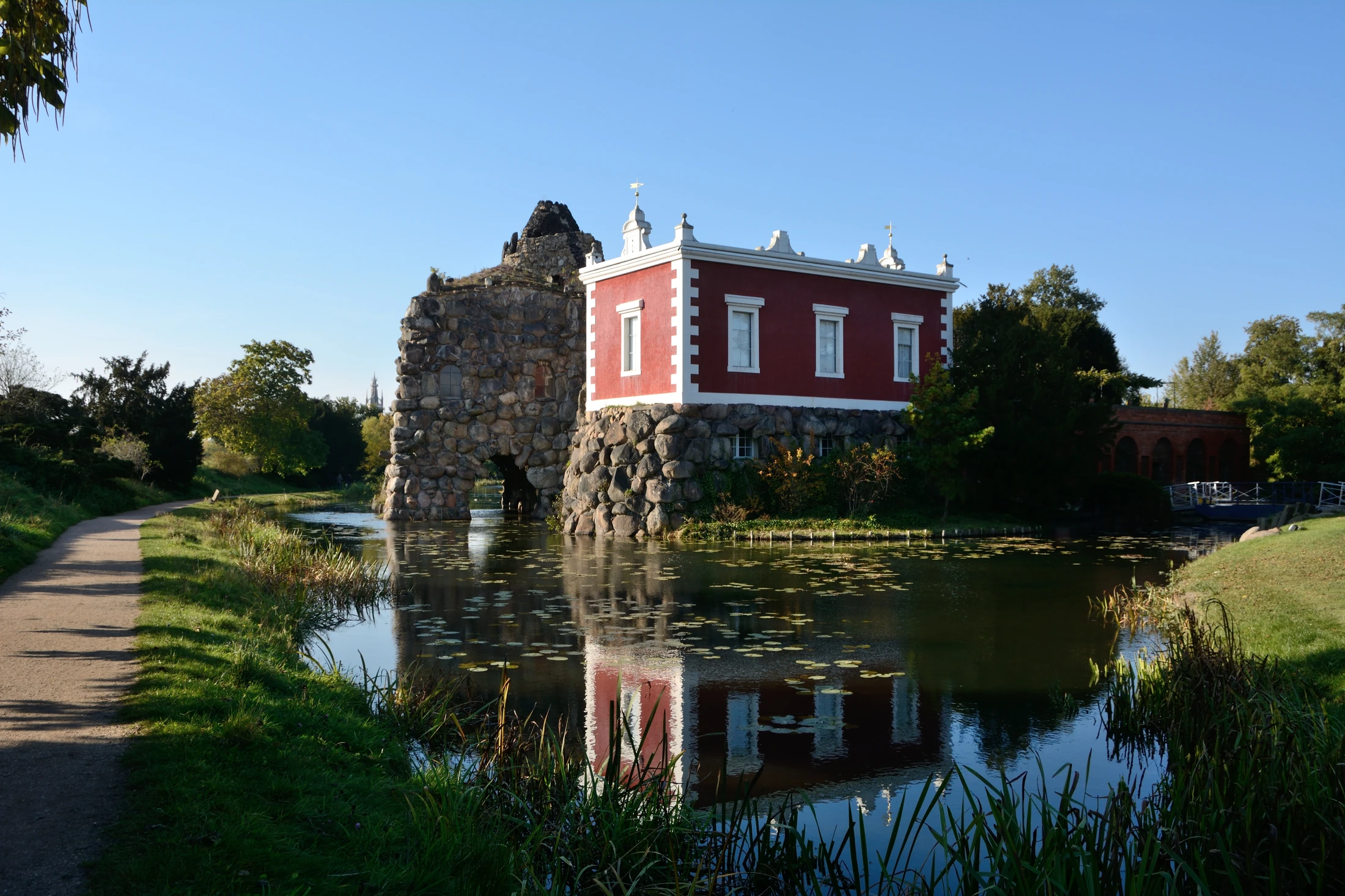 Stein Island in Wörlitz Park with rock architecture, a red villa and its reflection in the water